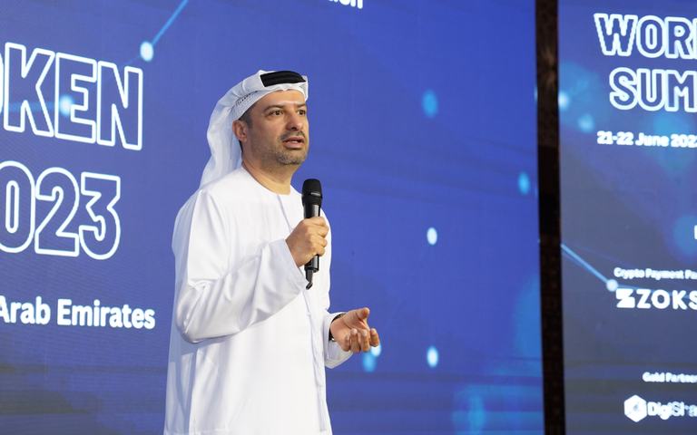 A speaker addressing a summit audience with a microphone