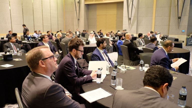 Delegates working with documents at tables during a session